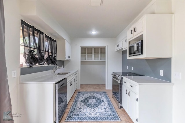 1026 Baylor St, Abilene, TX 79602 - kitchen featuring stainless steel microwave, a sink, dishwashing machine, light countertops, and range with electric cooktop