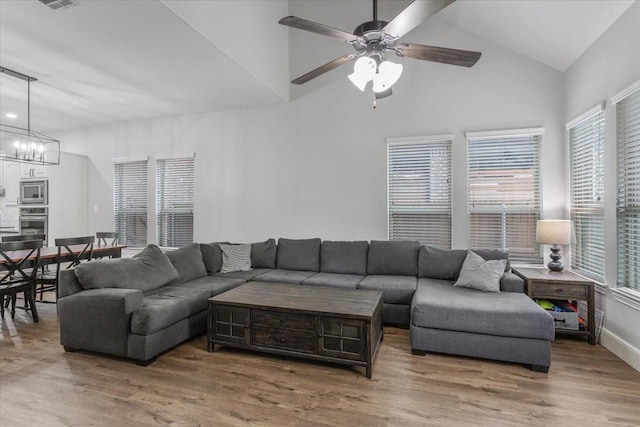living room featuring wood finished floors, a healthy amount of sunlight, and high vaulted ceiling