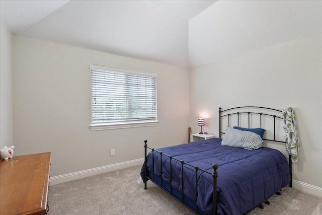carpeted bedroom with baseboards and lofted ceiling