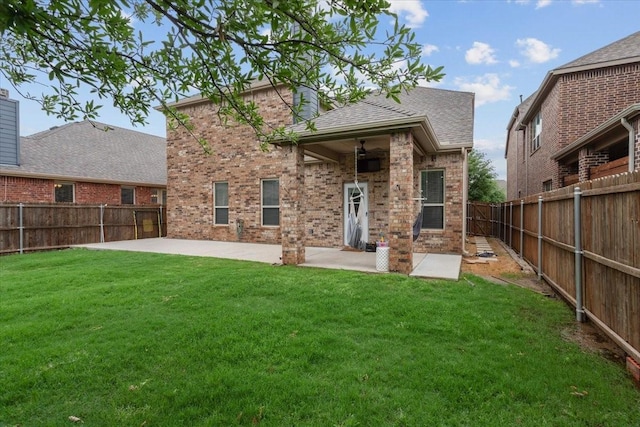 rear view of house with a patio, a fenced backyard, brick siding, a shingled roof, and a yard