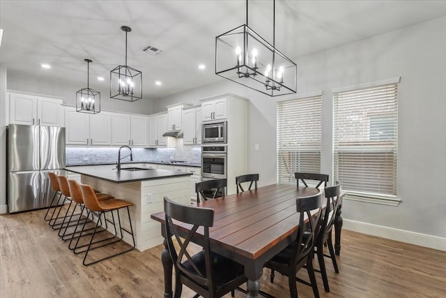 dining room featuring a notable chandelier, recessed lighting, baseboards, light wood-type flooring, and visible vents