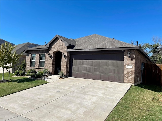 view of front of house featuring brick siding, a front yard, driveway, and a garage