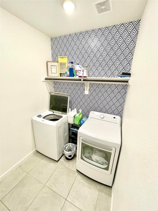 clothes washing area with light tile patterned floors, visible vents, laundry area, and independent washer and dryer