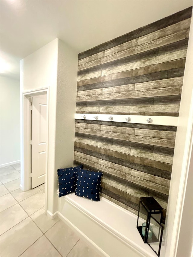 bathroom with wooden walls, baseboards, and tile patterned flooring