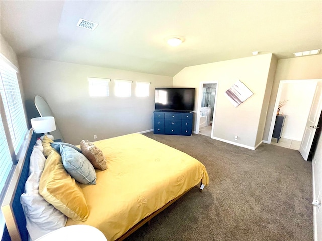 carpeted bedroom with lofted ceiling, baseboards, visible vents, and connected bathroom