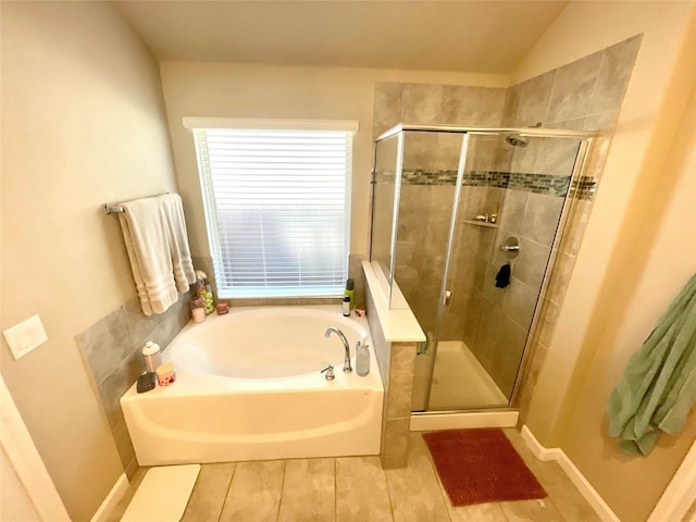 bathroom with lofted ceiling, a garden tub, and a shower stall