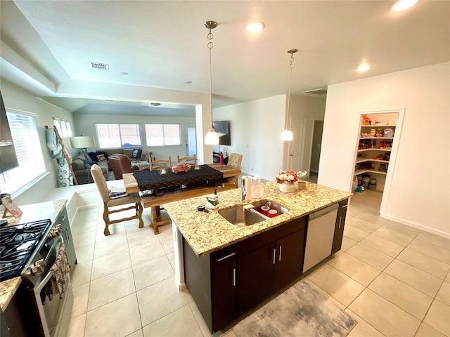 kitchen with a sink, a center island with sink, open floor plan, visible vents, and appliances with stainless steel finishes