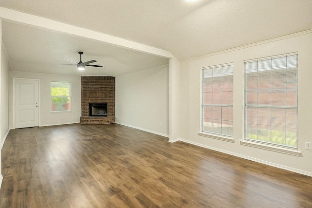 4823 Topaz Ln, Granbury, TX 76049 - unfurnished living room featuring baseboards, a ceiling fan, a brick fireplace, dark wood-type flooring, and ornamental molding