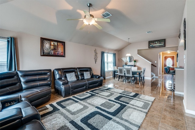 tiled living room with a ceiling fan, arched walkways, baseboards, lofted ceiling, and visible vents