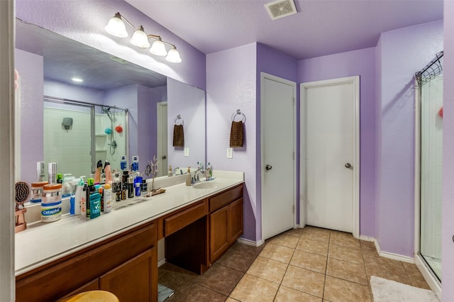 full bath featuring baseboards, visible vents, tile patterned flooring, a shower stall, and vanity