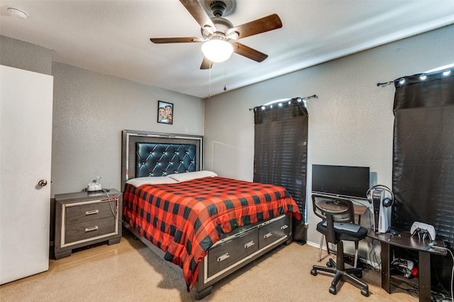 carpeted bedroom featuring a textured wall and a ceiling fan