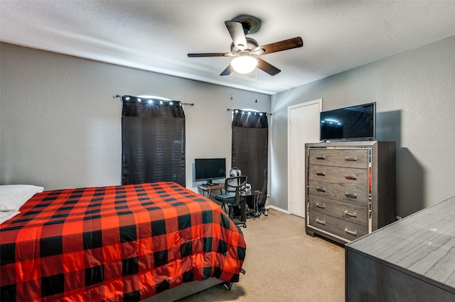 bedroom with ceiling fan, a textured wall, and light colored carpet