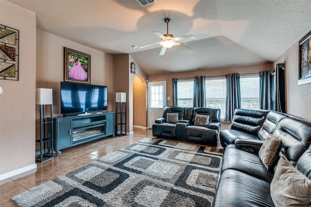 living area featuring arched walkways, baseboards, lofted ceiling, a ceiling fan, and light tile patterned floors