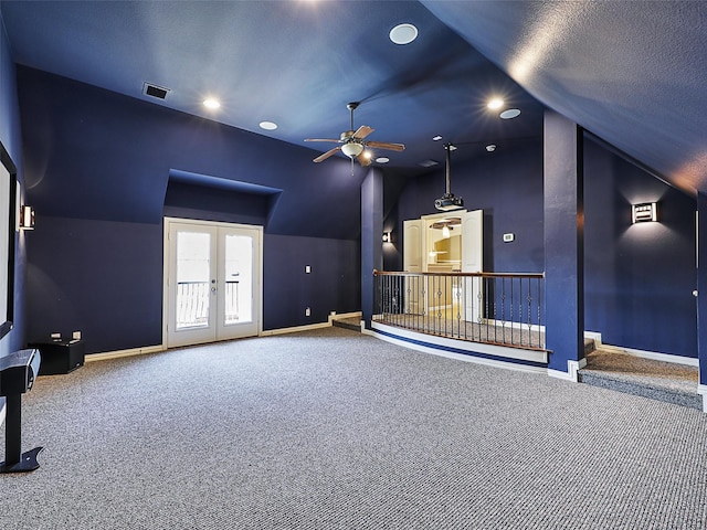 unfurnished living room featuring a ceiling fan, baseboards, lofted ceiling, carpet flooring, and visible vents