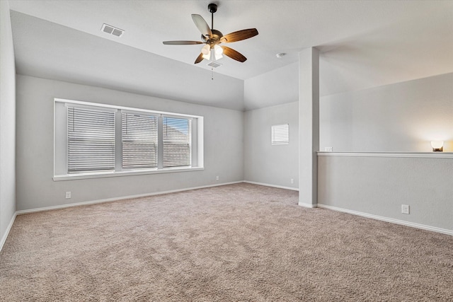 carpeted empty room featuring vaulted ceiling, visible vents, a ceiling fan, and baseboards