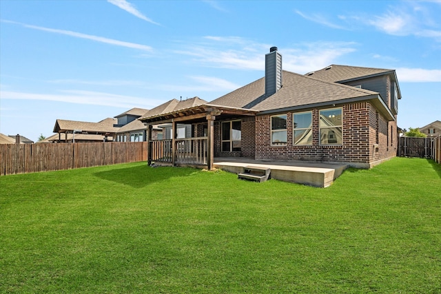 rear view of house with a fenced backyard, brick siding, roof with shingles, and a patio