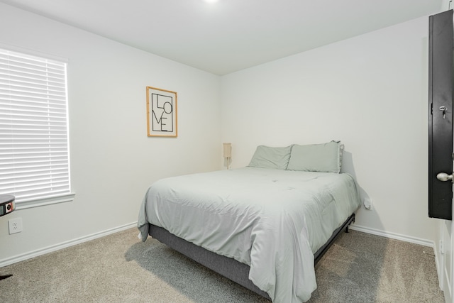 bedroom featuring baseboards and carpet