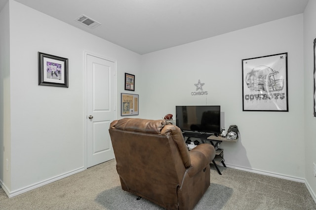 living area featuring baseboards, visible vents, and light colored carpet