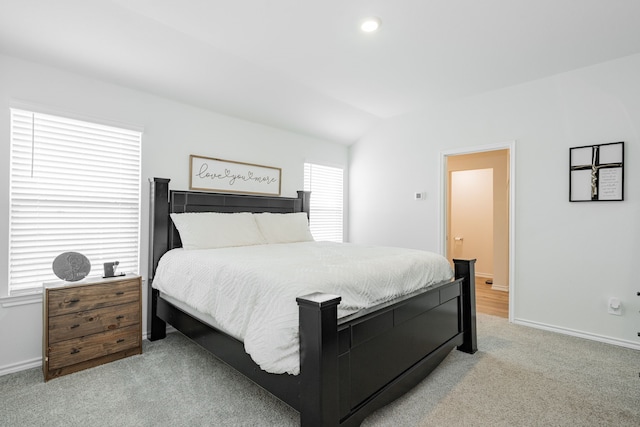bedroom featuring vaulted ceiling, baseboards, and light colored carpet