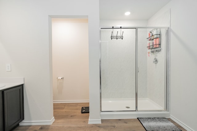full bath featuring a shower stall, vanity, and wood finished floors