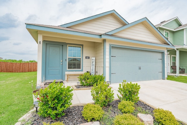view of front of property featuring an attached garage, fence, a front yard, and concrete driveway