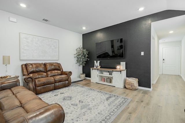 living room with recessed lighting, light wood-style flooring, visible vents, and baseboards