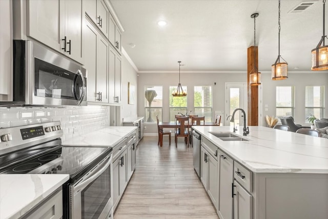12409 Messer Ct, Fort Worth, TX 76126 - kitchen with appliances with stainless steel finishes, a sink, crown molding, light wood-style floors, and tasteful backsplash