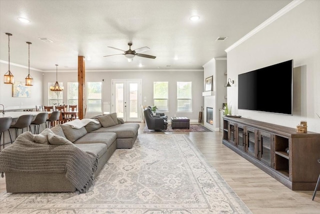 12409 Messer Ct, Fort Worth, TX 76126 - living area with light wood finished floors, ceiling fan, recessed lighting, crown molding, and a glass covered fireplace