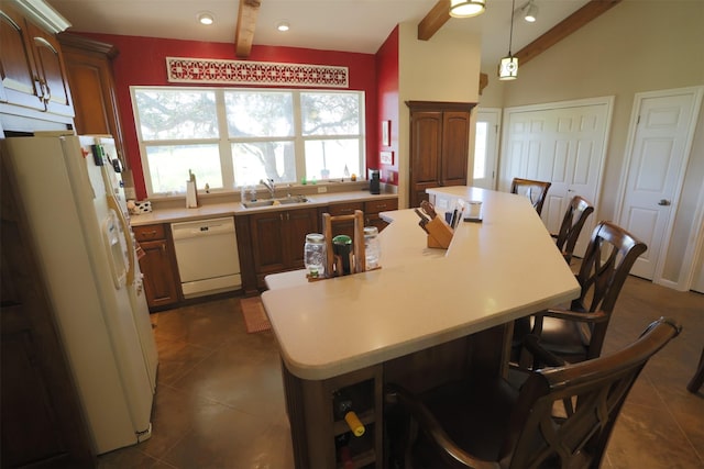 kitchen with a breakfast bar area, a sink, white appliances, and light countertops