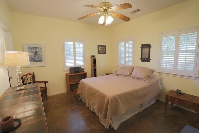 bedroom with multiple windows, visible vents, and dark tile patterned flooring