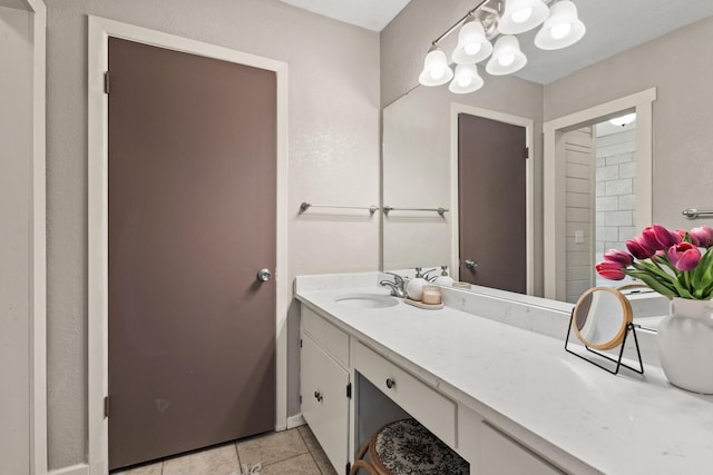bathroom with baseboards, tile patterned floors, and vanity