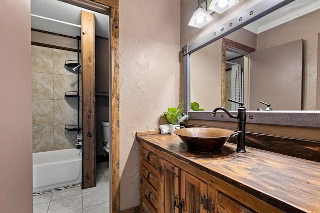 bathroom featuring tile patterned flooring, a textured wall, toilet, vanity, and ornamental molding