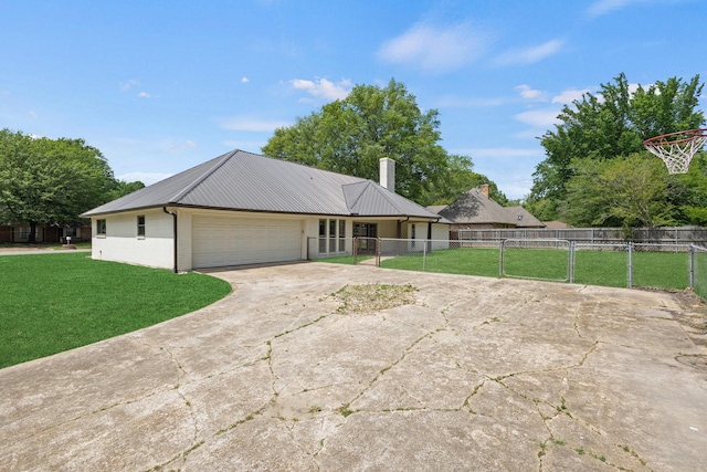 ranch-style house featuring concrete driveway, metal roof, fence, a front yard, and a garage