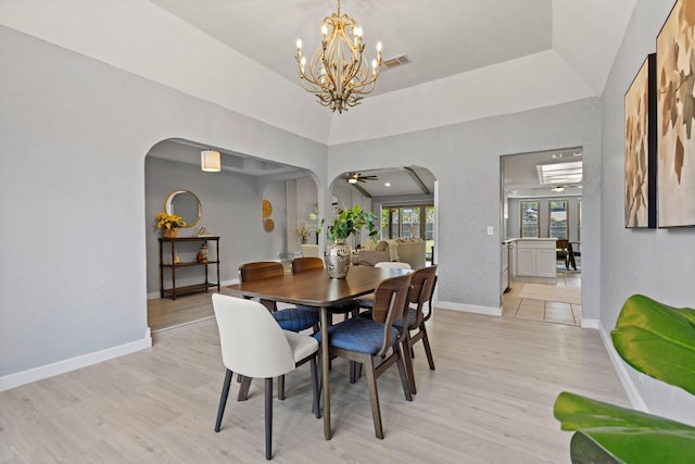 dining room featuring baseboards, arched walkways, a chandelier, and light wood-type flooring