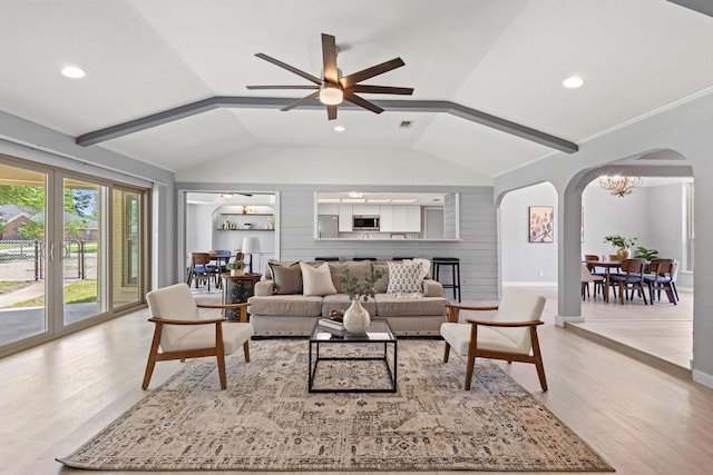 living area with recessed lighting, vaulted ceiling, arched walkways, light wood-style floors, and ceiling fan