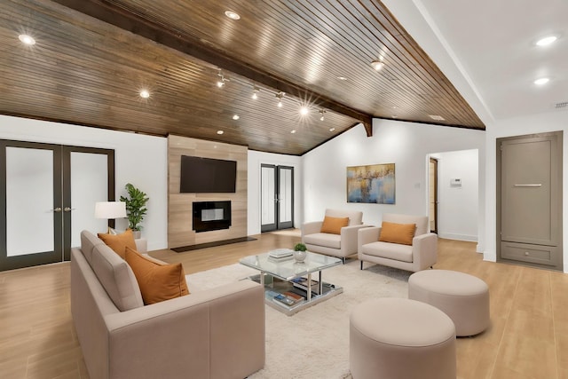 living area with recessed lighting, french doors, light wood-type flooring, lofted ceiling with beams, and a fireplace