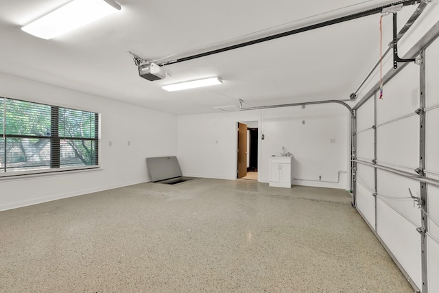 garage with baseboards and a garage door opener