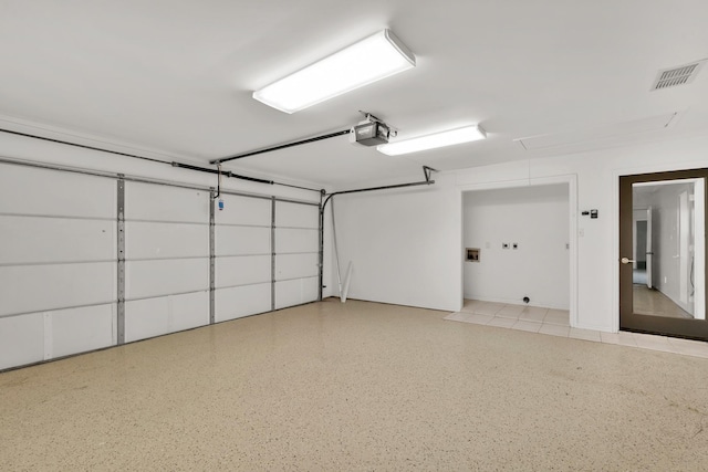 garage with a garage door opener and visible vents