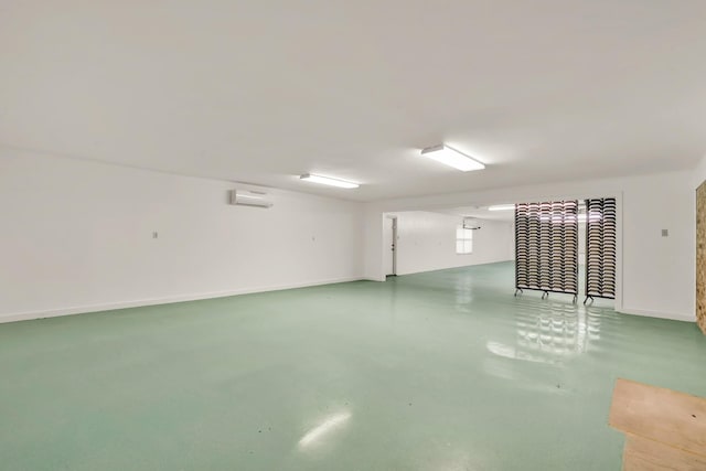 below grade area featuring a wall mounted air conditioner and baseboards