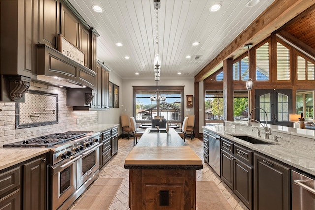 kitchen with recessed lighting, a center island with sink, stainless steel appliances, and a sink