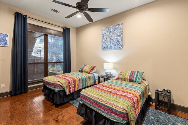 bedroom featuring wood finished floors, visible vents, a ceiling fan, and baseboards