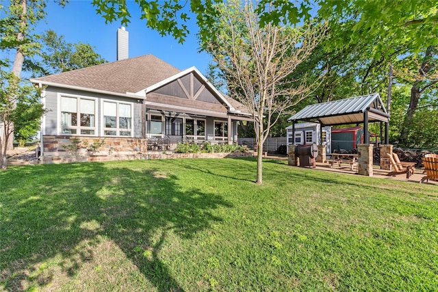 rear view of house with a patio area, a lawn, a chimney, and fence