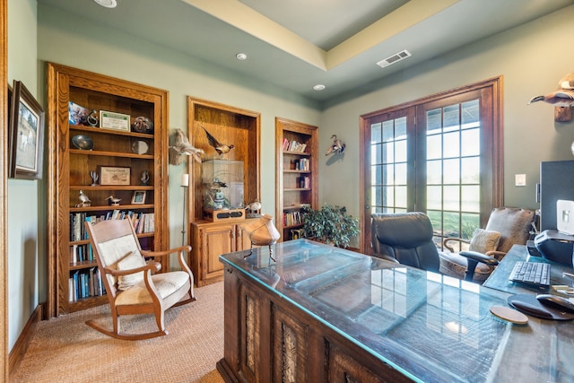 office with light colored carpet, a raised ceiling, built in shelves, recessed lighting, and visible vents