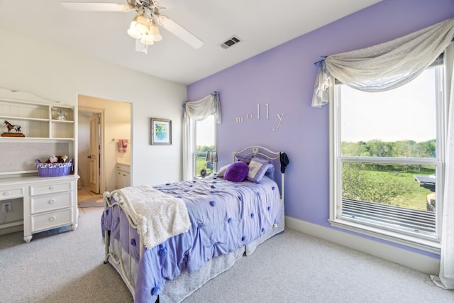 bedroom featuring visible vents, a ceiling fan, connected bathroom, and light colored carpet