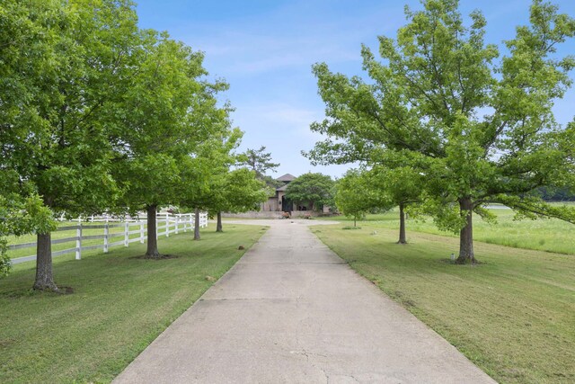 view of property's community with a lawn and fence