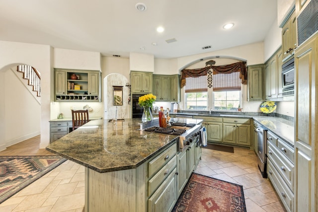 kitchen featuring visible vents, a center island, recessed lighting, green cabinetry, and appliances with stainless steel finishes