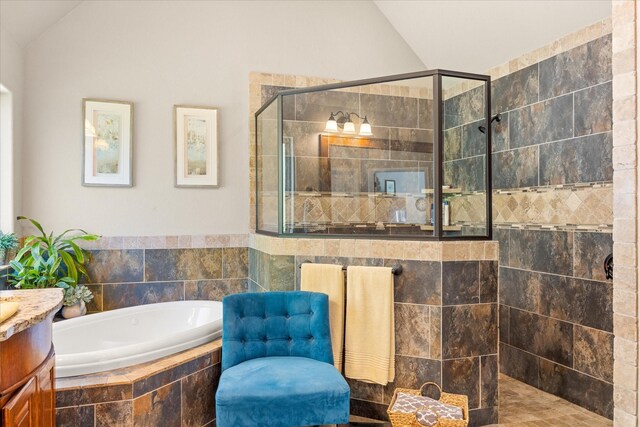 bathroom with vanity, vaulted ceiling, a stall shower, and a bath