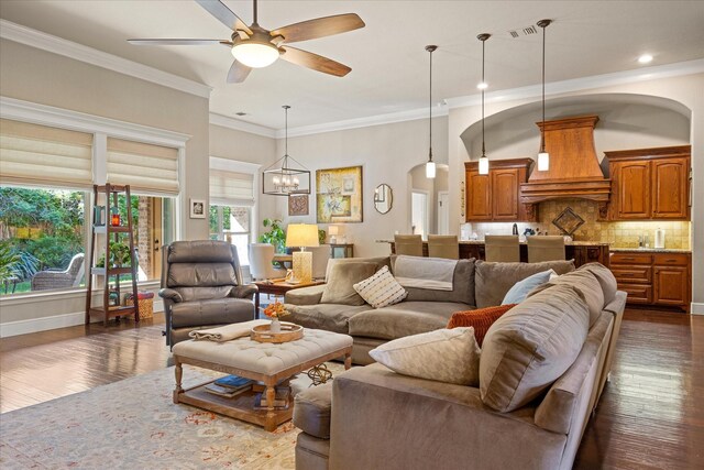 living room featuring visible vents, arched walkways, dark wood-type flooring, and ceiling fan with notable chandelier