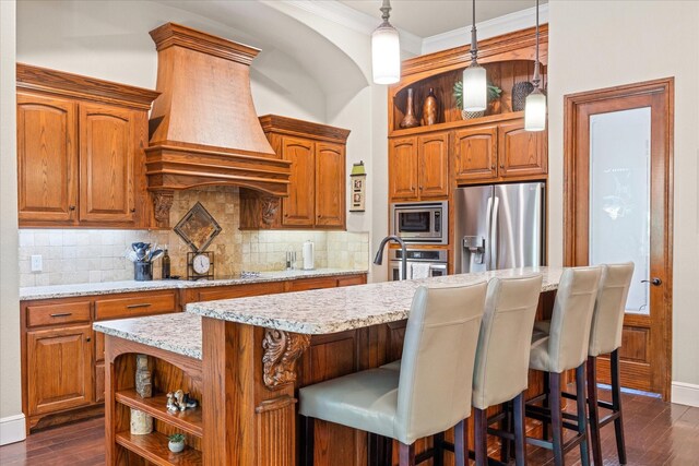 kitchen featuring decorative backsplash, a center island with sink, dark wood-type flooring, custom range hood, and stainless steel appliances