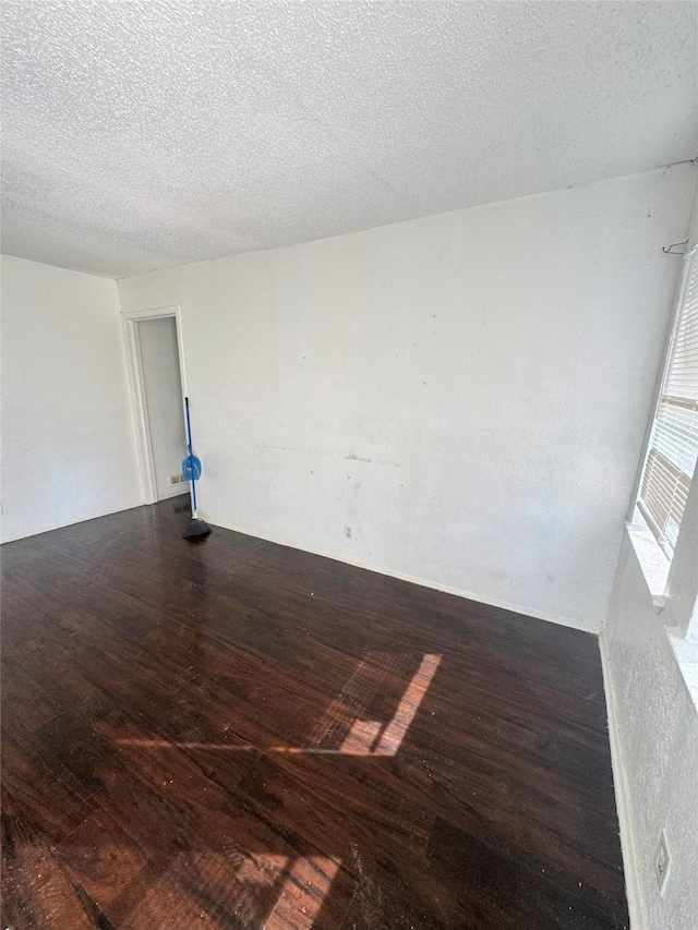 spare room featuring hardwood / wood-style flooring and a textured ceiling